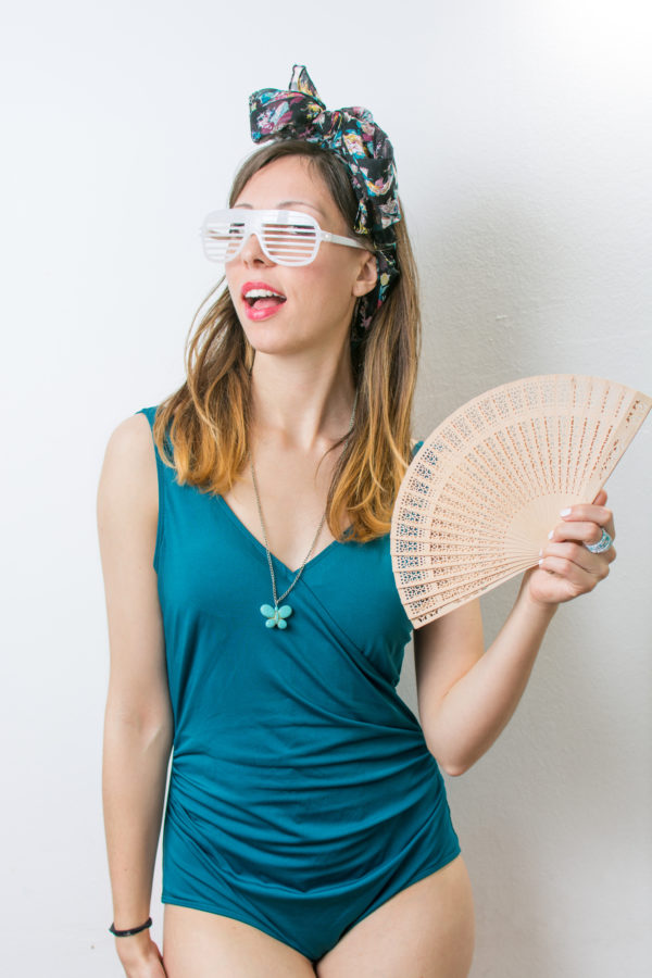 wearing scarf as headband with bathing swimsuit holding fan